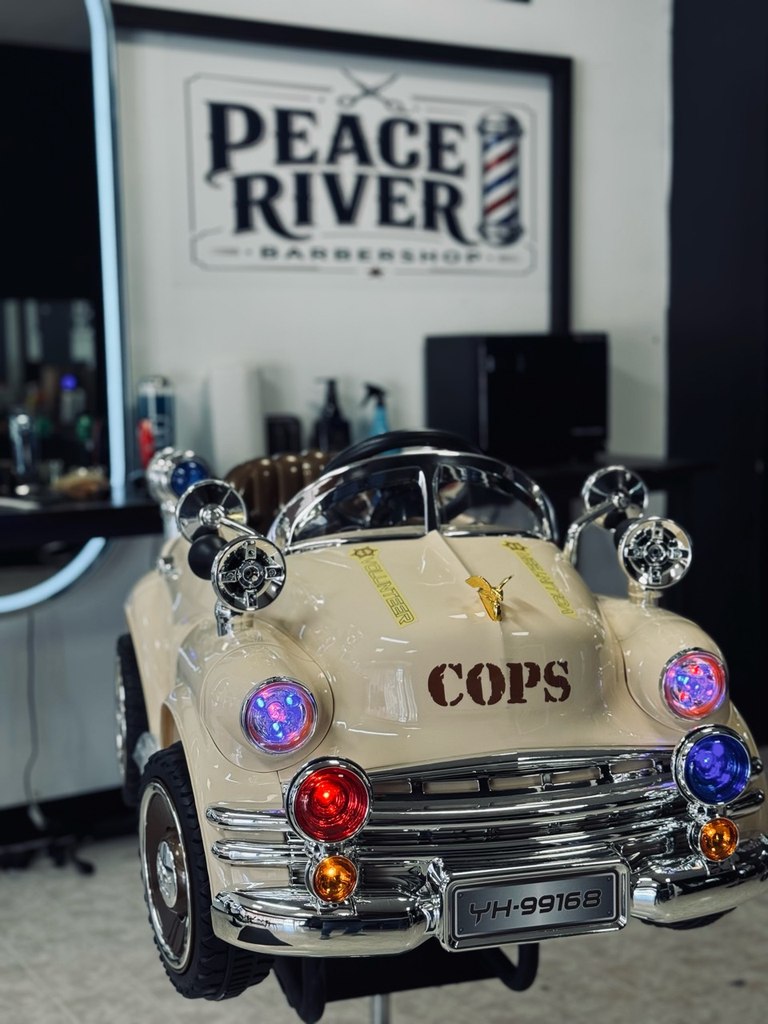 The cream car-shaped kids barber chair inside Peace River Barbershop