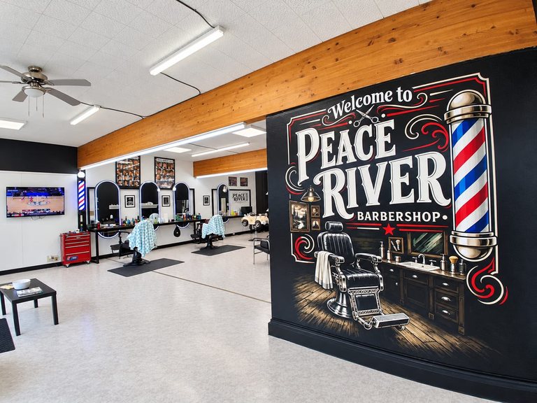 The Peace River Barbershop wall painting beside the shop’s barber stations